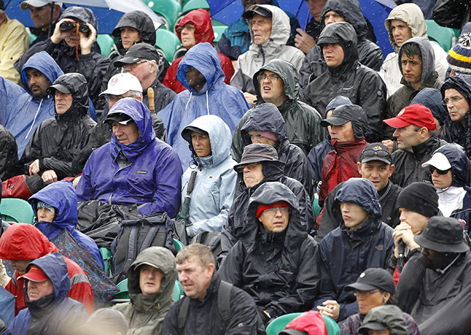 Summer 2011: Sandwich: Spectators watch play in heavy rain at the British Open