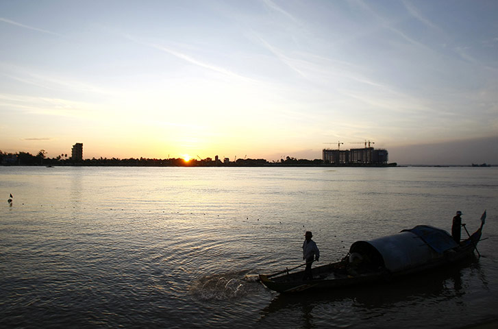 24 hours in pictures: Phnom Penh, Cambodia: Cambodian fishermen row their wooden boat, Tonle Sap