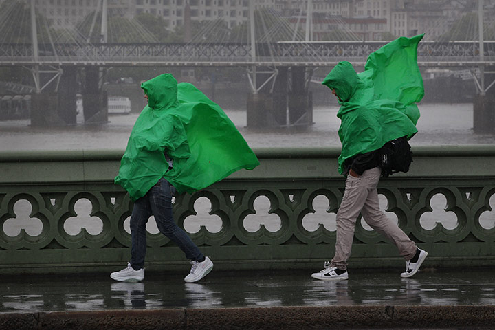 Summer 2011: London: Tourists wearing green ponchos struggle in wet and windy conditions