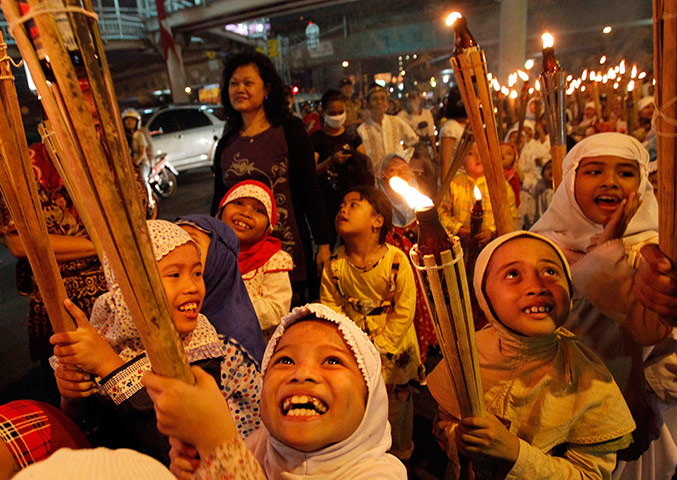 Eid Festival: Children march through a street carrying torches to mark the end of Ramadan