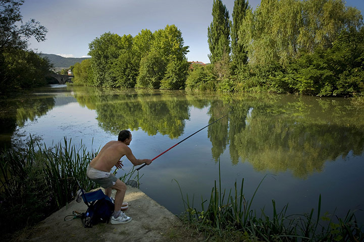 24 Hours : Pamplona, Spain: A man enjoy the day as he fishing on the Arga River