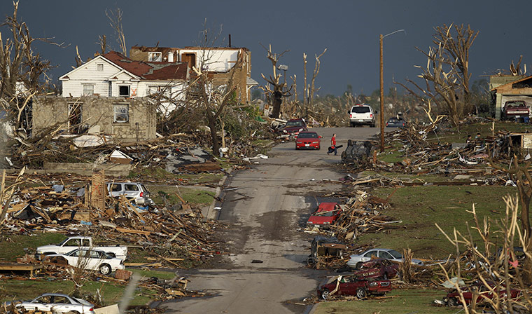 A man salvages a guitar from his wrecked home in Joplin, Missouri
