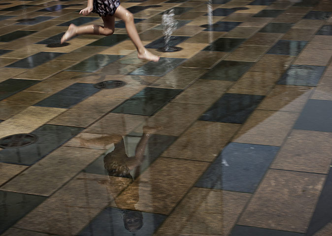 24 hours in pictures: A child plays in a fountain in Beijing