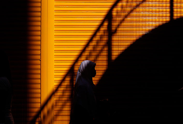 24 hours in pictures: An Indonesian woman walks along a street in Hong Kong, China
