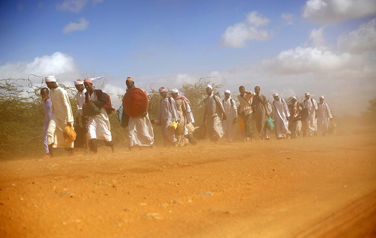 24 hours in pictures: Muslim clerics walk in the dust on the dirt road Dadaab, Kenya