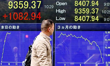 Man passes electronic board displaying Nikkei share average in Tokyo