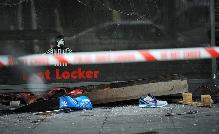 London Riots: Looted goods lie on the pavement outside a fire-damaged footwear shop