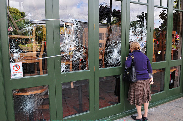 London riots day 4: A chair is left embedded in a restaurant window in Haven Green in Ealing