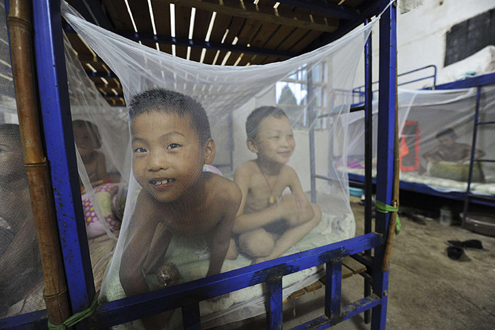 24 hours in pictures: Feidong county, China: Students play on beds covered by mosquito nets