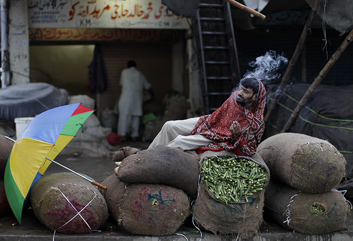 24 hours in pictures: Islamabad, Pakistan: A vegetable vendor smokes a cigarette
