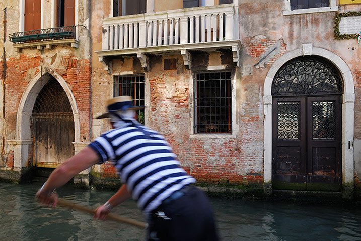 Week in Business: A working gondolier rowing on a canal in Venice