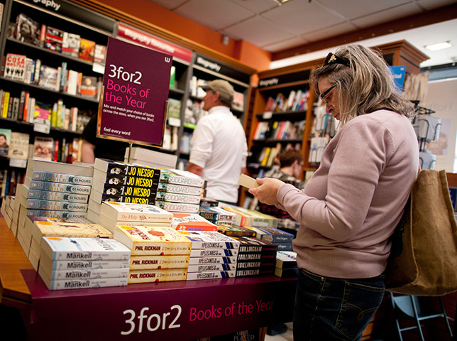 Week in Business: A woman browsing 3 for 3 offer books in Waterstones bookshop UK