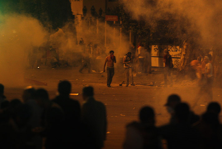 Egypt Riots: Protesters throw stones as tear gas is seen around them in Cairo