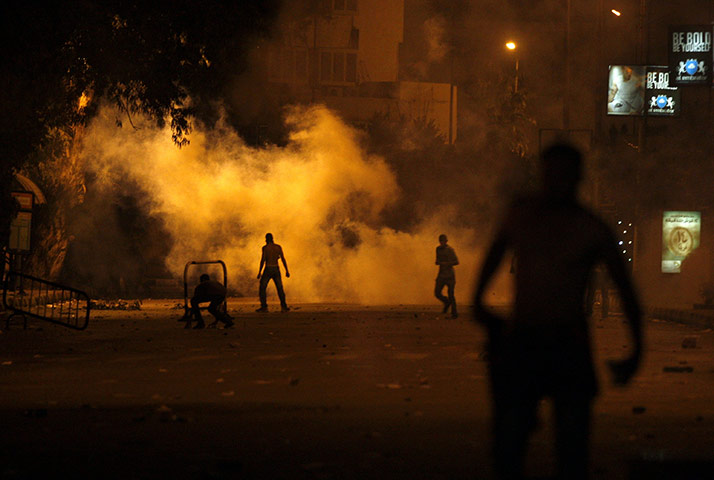 Egypt Riots: Protesters throw stones as tear gas rises at the Israeli embassy in Cairo