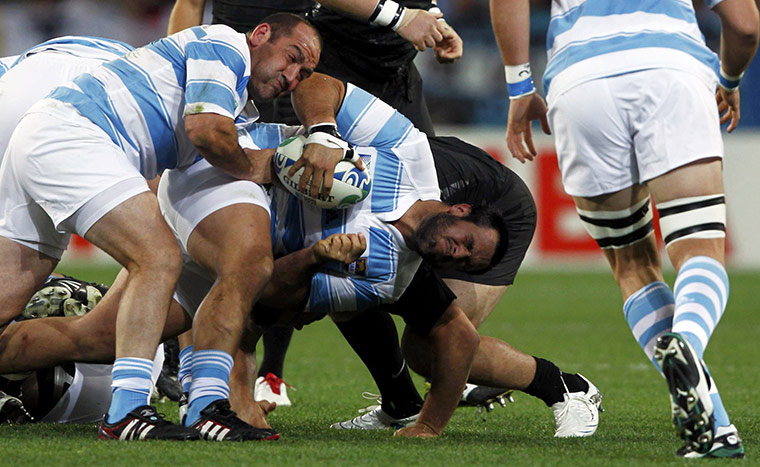 Argentina v England : Argentina's Juan Figallo is brought down alongside teammate Rodrigo Roncero