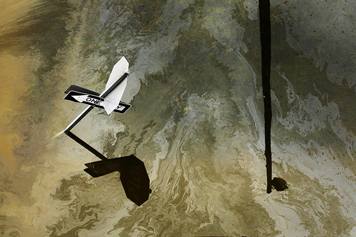 24 Hours: A sheen of oil on the water during flooding caused by Tropical Storm Lee 