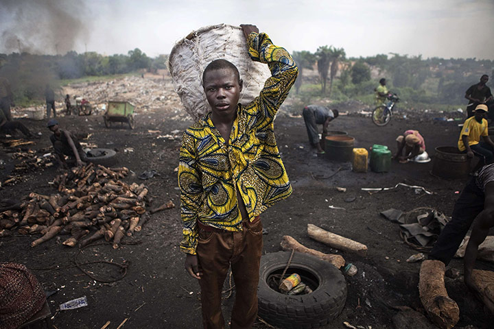 24 hours: Niamey, Niger: A worker carries a basket through an outdoor meat market 