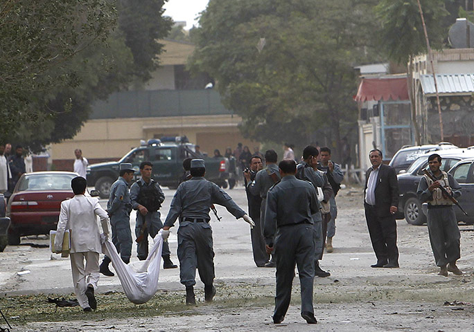 Kabul embassy attacks: Afghan policemen carry the body of a suicide attackerin Kabul