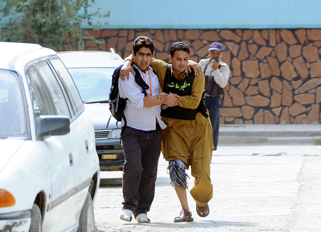 Kabul embassy attacks: A wounded man is helped away from the scene  of an attack  in Kabul