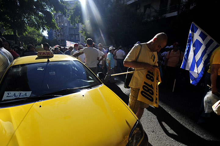 24 hours in pictures: Greek taxi drivers hold banners and flags during a strike