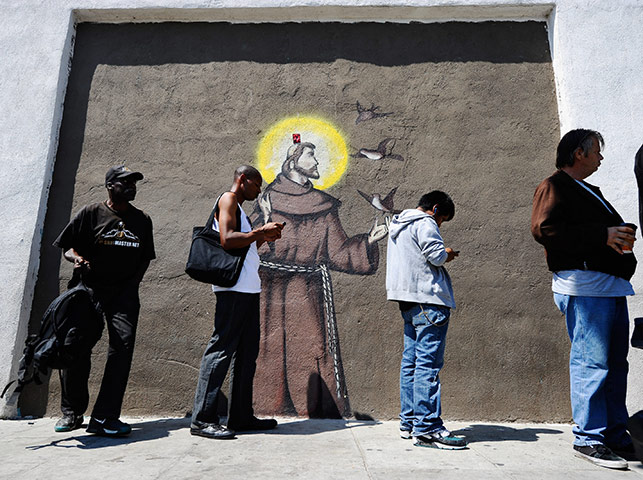 24 hours in pictures: People wait outside of St. Francis Centre soup kitchen in Los Angeles