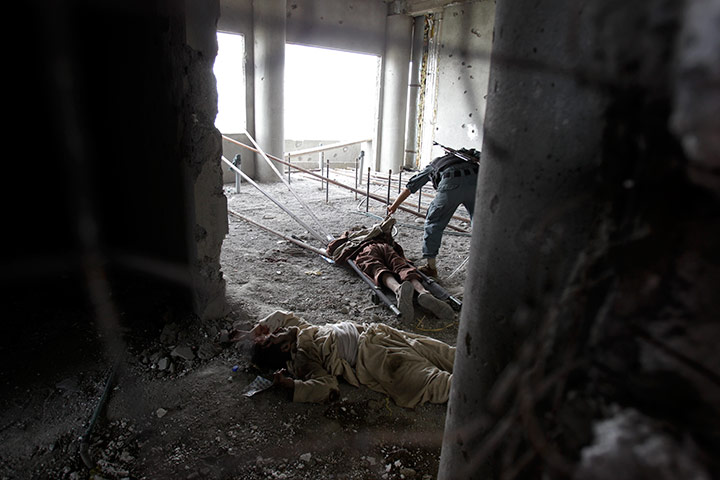 24 hours in pictures: Afghan military personnel check bodies in Kabul