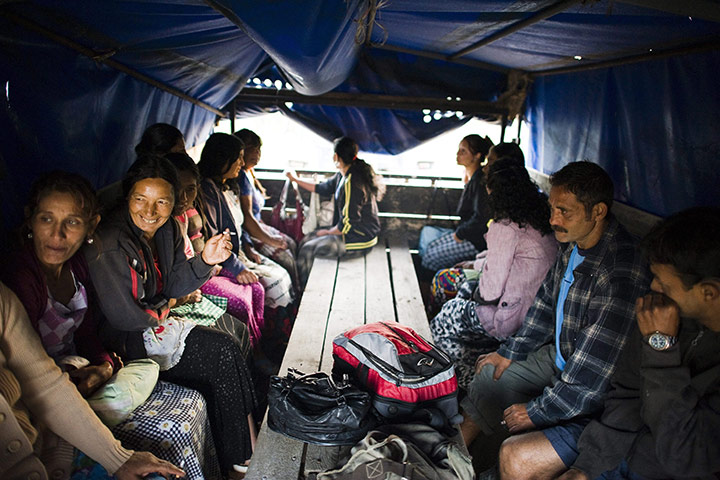 FTA: Attila Balazs: Day-workers ride on the trailer of a tractor into the peach orchards