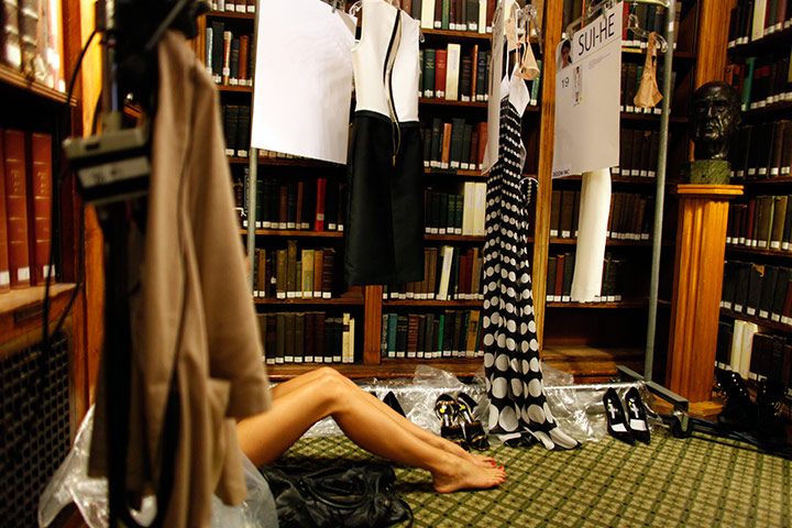 24 hours in pictures: A model sits on the floor backstage before the Bill Blass show
