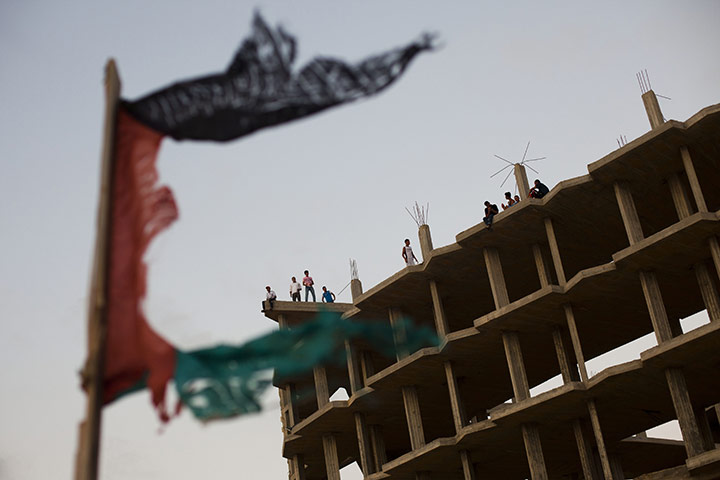 24 Hours: Palestinians gather on the rooftop of a building which was bombed