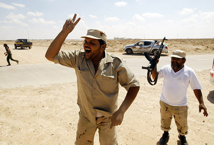 Sirte: Anti-Gaddafi fighters gesture during a battle