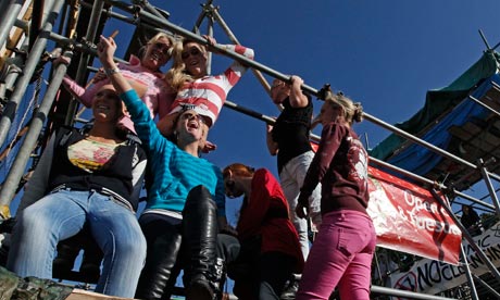 Travellers sit on a scaffolding forming part of a blockade at the Dale Farm site