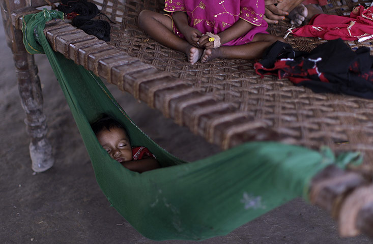 24 hours: Pakistan: A child displaced by floods sleeps in a hammock at a shanty