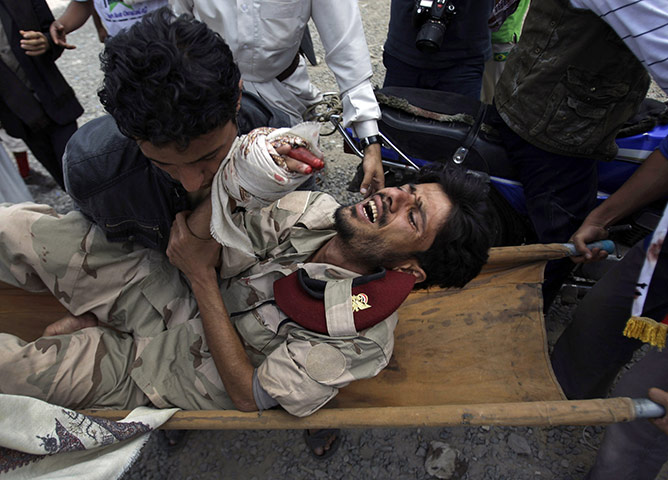 yemen : Protestors carry a wounded soldier