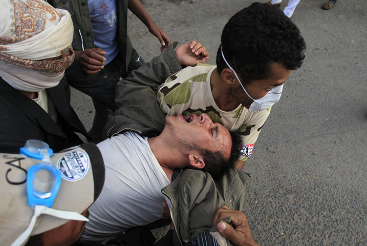 yemen : Anti-government protesters carry an injured comrade