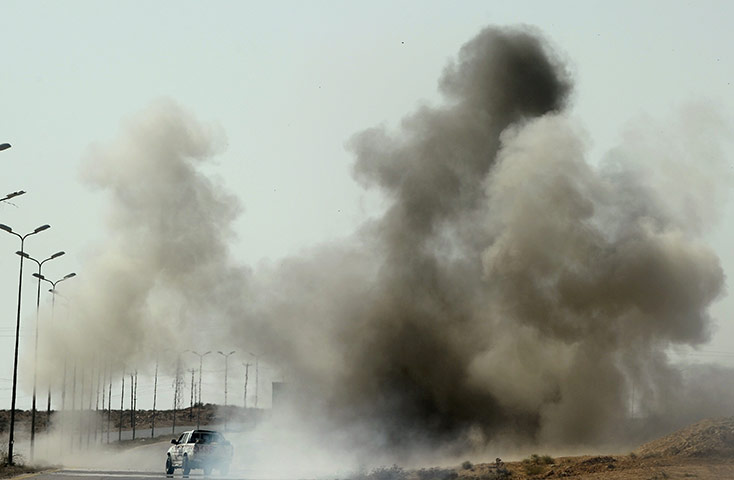 LIbya fighting continues: A Libyan NTC logistics car drives through smoke  on the outskirts of Sirte
