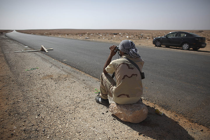 Libya fighting continues: A rebel fighter guards the highway leading to Bani Walid, at Wadi Dinar