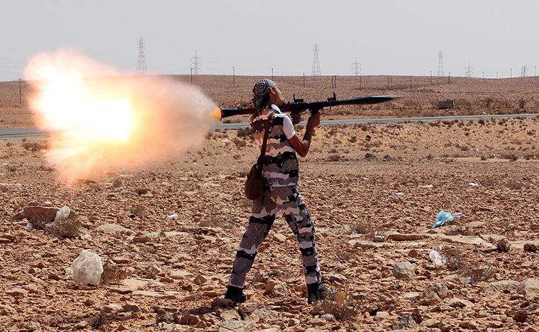 Libya fighting continues: A Libyan rebel fires an RPG during a shooting practice near Bani Walid