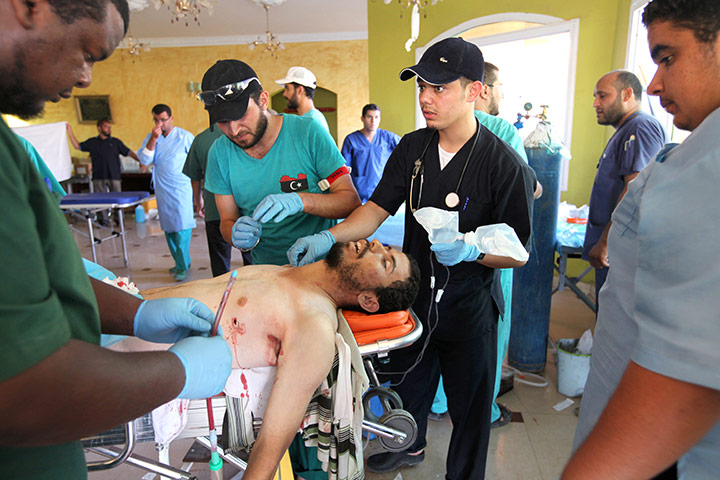 Libya fighting continues: Volunteer medics at a field hospital clean the body of a fighter