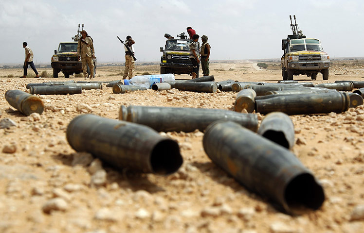 Libya fighting continues: Anti-Gaddafi fighters stand outside a village near Sirte
