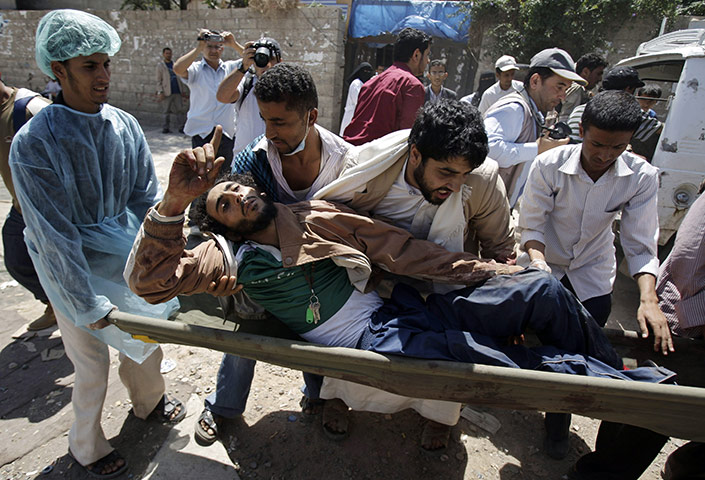 Yemen violence: Anti-government protesters carry an injured protester from clashes 