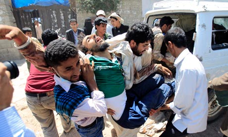 Medics carry a wounded anti-government protester in Sanaa