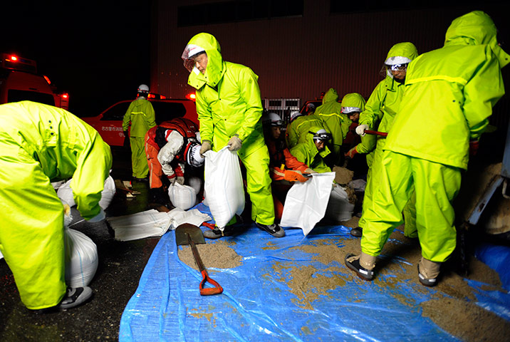 Typhoon Roke: Rescue team members prepare sand bags to secure a river bank in Nagoya
