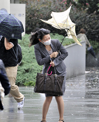 Typhoon Roke: A woman braves strong winds as Typhoon Roke hits the Tokyo area