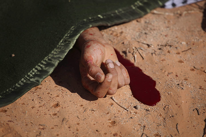 24 hours in pictures: A rebel fighter lays shrouded after a rocket propelled grenade accident