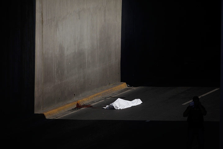 24 hours in pictures: The slain body of a man is covered with a white sheet, Mexico