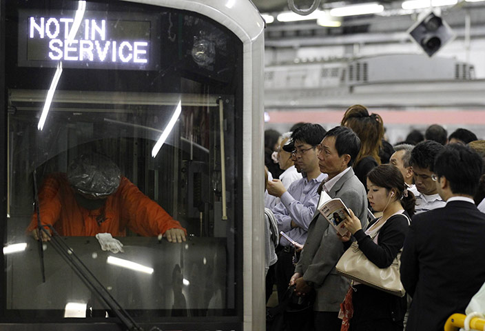 Typhoon Roke, Japan: Passengers wait for the resumption of a train service at Shibuya station