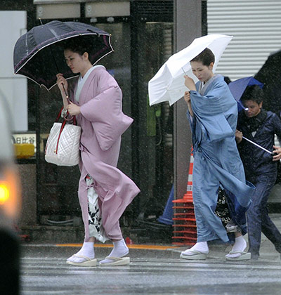 Typhoon Roke, Japan: Two women in kimonos make their way through rain in Tokyo's Ginza area 