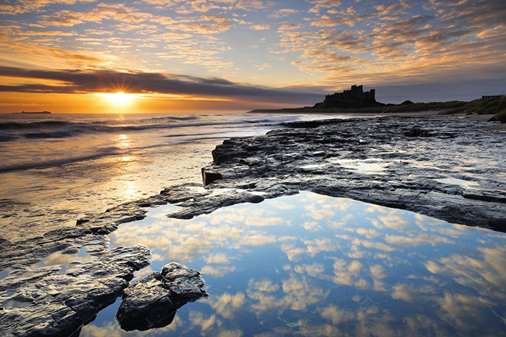 The Sea: The sun rises over the coast near Bamburgh Castle, Northumberland