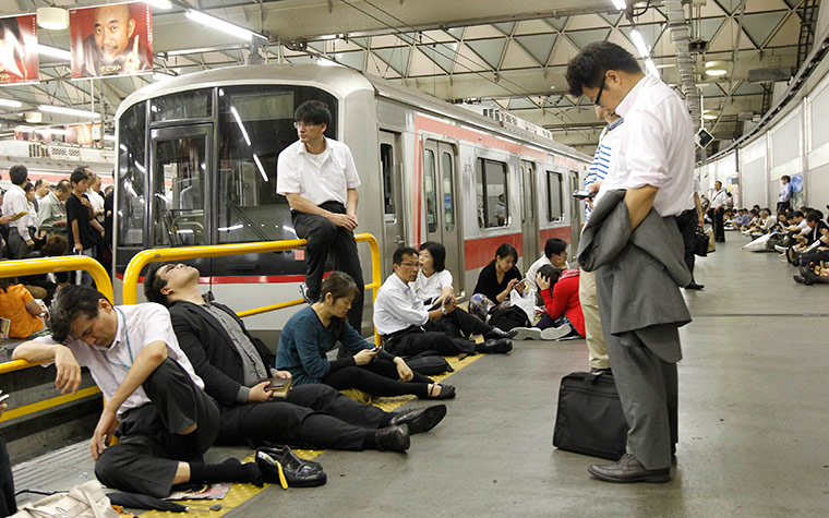 Typhoon Roke: Passengers wait for the resumption of train service in Tokyo