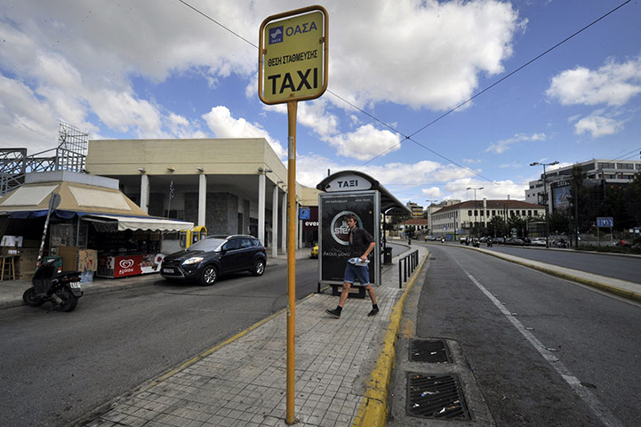 Strike in Greece: A tourist walks past a deserted taxi station in Athens